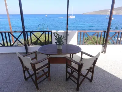 a table and two chairs with a table and the ocean at ANEMOESSA APTS in Livadia