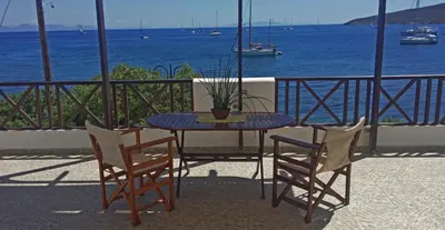 a table with chairs and a potted plant on a balcony at ANEMOESSA APTS in Livadia