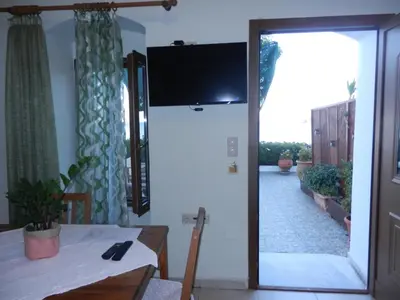 a dining room with a table and a sliding glass door at ANEMOESSA APTS in Livadia