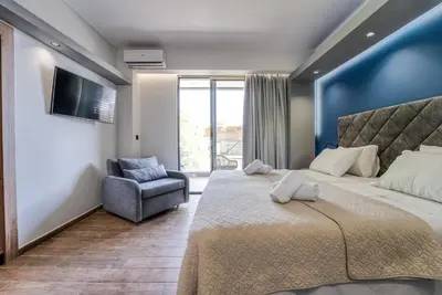 a bedroom with a large bed and a chair at Island City Boutique Hotel in Rhodes Town