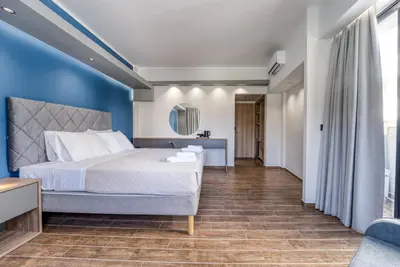 a bedroom with a bed and a blue wall at Island City Boutique Hotel in Rhodes Town