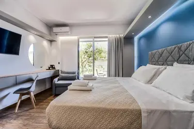 a bedroom with a large bed and a chair at Island City Boutique Hotel in Rhodes Town