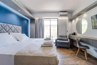 a bedroom with a large bed and a chair at Island City Boutique Hotel in Rhodes Town