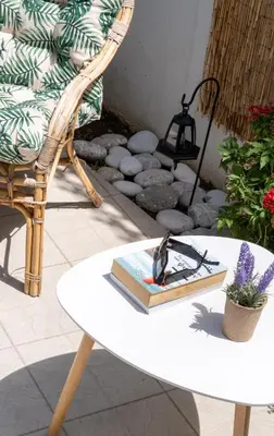 a chair and a table with a book and a lamp at VillaBlu Apartments in Asgourou