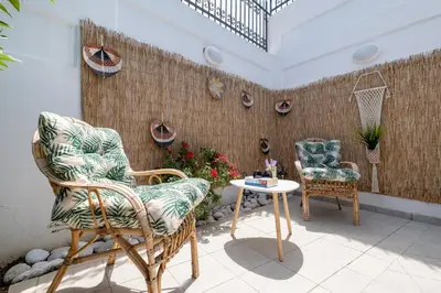 a patio with two chairs and a table and a basketball hoop at VillaBlu Apartments in Asgourou