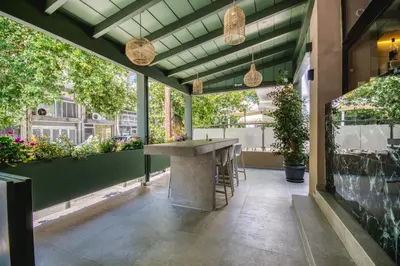 a patio with a table and potted plants at Astron Hotel Rhodes in Rhodes Town