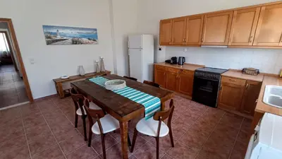 a kitchen with a table with chairs and a refrigerator at Dimitra - Kattavia surf houses in Kattavía