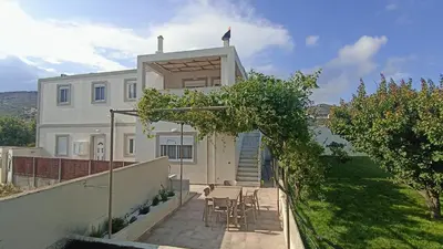 a white house with chairs and tables in front of it at Dimitra - Kattavia surf houses in Kattavía