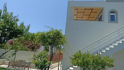 a building with a staircase and tables and trees at Dimitra - Kattavia surf houses in Kattavía