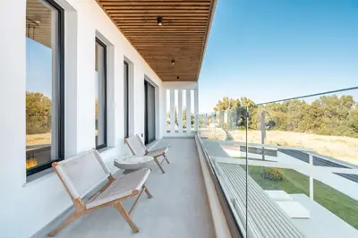 a balcony with two chairs and glass windows at D&R Boutique Villas R in Gennadi