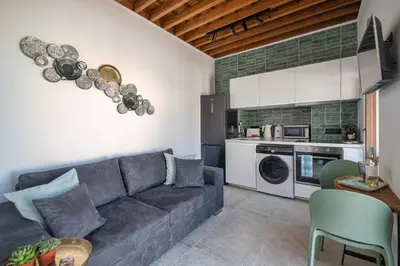 a living room with a couch and a kitchen at Villa Danae - Lindos in Líndos