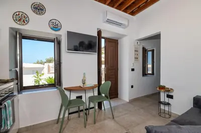 a living room with a table and chairs and a window at Villa Danae - Lindos in Líndos