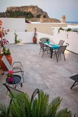 a patio with chairs and a table on a roof at Villa Danae - Lindos in Líndos