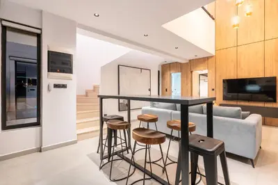 a kitchen and living room with a bar and stools at D&R Boutique Villas D in Gennadi