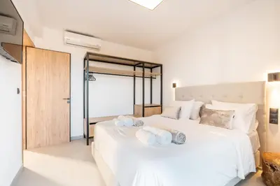 a bedroom with a large white bed with towels on it at D&R Boutique Villas D in Gennadi