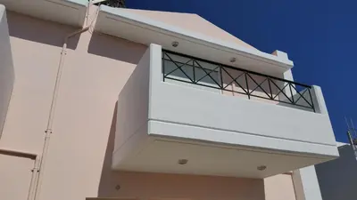 a balcony on the side of a white building at orange in Ialyssos