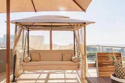 a porch with a couch under an umbrella at Halide Luxury Villa in Ixia
