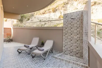 three chairs sitting on a patio with a wall at Halide Luxury Villa in Ixia