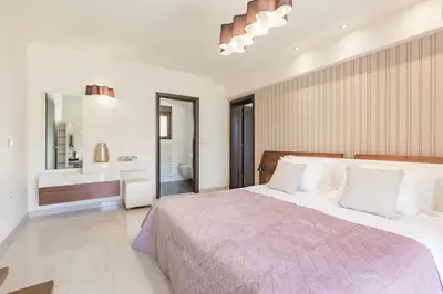 a bedroom with a large bed and a bathroom at Halide Luxury Villa in Ixia