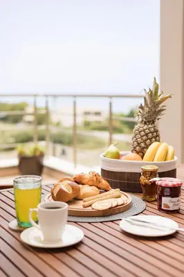 a table with a plate of bread and a cup of coffee at Halide Luxury Villa in Ixia