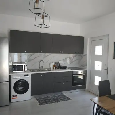 a kitchen with a sink and a washing machine at Restaurant Maria Suites SunRise in Faliraki