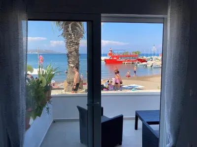 a view of a beach from a room with a window at Restaurant Maria Suites SunRise in Faliraki