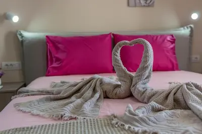 two towel swans laying on top of a bed at Extreme House in Archangelos