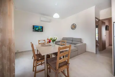 a dining room with a table and chairs and a couch at Extreme House in Archangelos