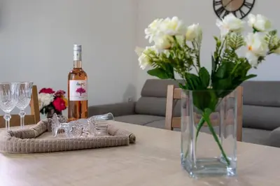 a bottle of wine and a vase of flowers on a table at Extreme House in Archangelos