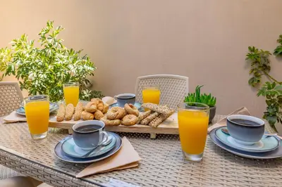 a table with a tray of food and orange juice at Panormos Luxury House in Rhodes Town