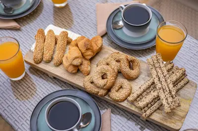 a table with a tray of pretzels and coffee and orange juice at Panormos Luxury House in Rhodes Town