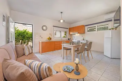 a living room and kitchen with a couch and a table at Panormos Luxury House in Rhodes Town