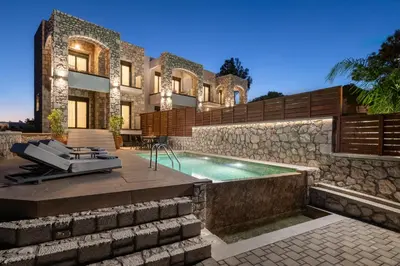 a house with a swimming pool in front of it at Seaesta Villas in Koskinou
