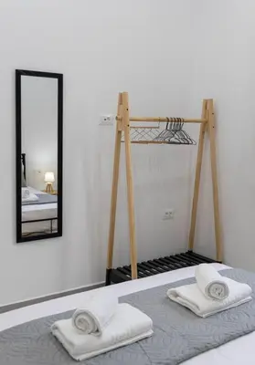 a room with a bed with two towels and a mirror at Nikolias dream house in Ialyssos