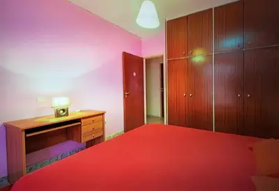 a bedroom with a red bed and a wooden desk at Rhodos town apartment in Rhodes Town
