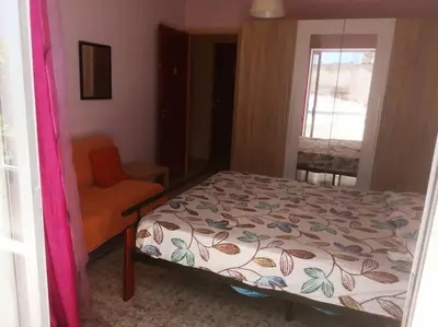 a bedroom with a bed and a chair and a window at Rhodos town apartment in Rhodes Town