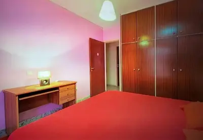 a bedroom with a red bed and a wooden desk at Rhodos town apartment in Rhodes Town