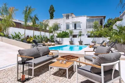 a patio with chairs and a swimming pool at My Pixida Apartments in Rhodes Town