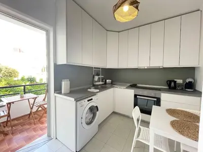 a kitchen with a washing machine and a table at Gravity Ialysos Scandi Suite in Ialyssos