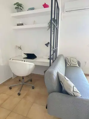 a living room with a couch and a desk at Gravity Ialysos Scandi Suite in Ialyssos