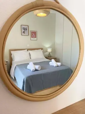 a bedroom with a bed in a round mirror at Gravity Ialysos Scandi Suite in Ialyssos