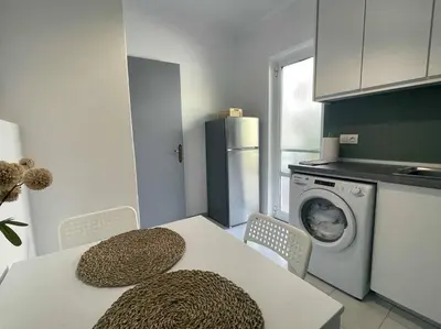 a kitchen with a table and a washing machine at Gravity Ialysos Scandi Suite in Ialyssos