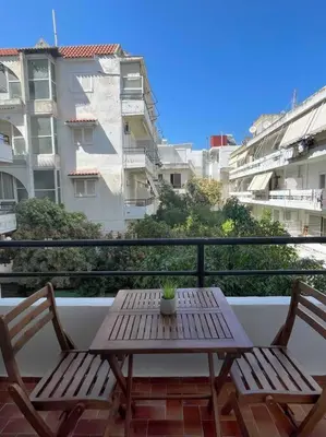 a wooden table and two chairs on a balcony at Gravity Ialysos Scandi Suite in Ialyssos