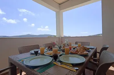 a table with plates of food on top of a balcony at Kristallia - Kattavia surf houses in Kattavía