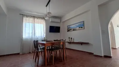 a dining room with a wooden table and chairs at Kristallia - Kattavia surf houses in Kattavía
