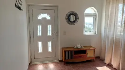 a room with a door and a table and a mirror at Kristallia - Kattavia surf houses in Kattavía