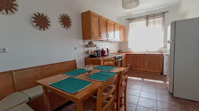 a kitchen with a wooden table and a refrigerator at Kristallia - Kattavia surf houses in Kattavía