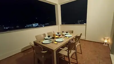a dining room with a table and chairs and a window at Kristallia - Kattavia surf houses in Kattavía