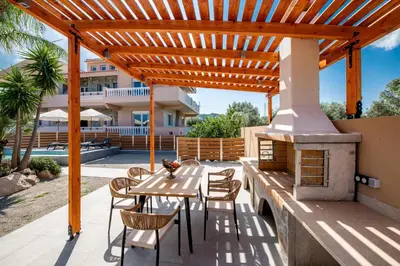 a patio with a wooden pergola and a table and chairs at Luxury Villa Barbara Afandou Rhodes in Afantou