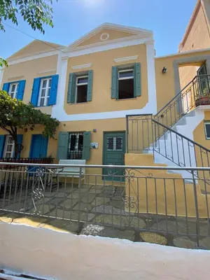 a house with a fence in front of it at ALEMINAS House 1 in Symi